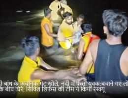 कागदी बांध के अचानक गेट खोले, नदी में फंसा युवक:बचाने गए लोग भी पानी के बीच घिरे; सिविल डिफेंस की टीम ने किया रेस्क्यू